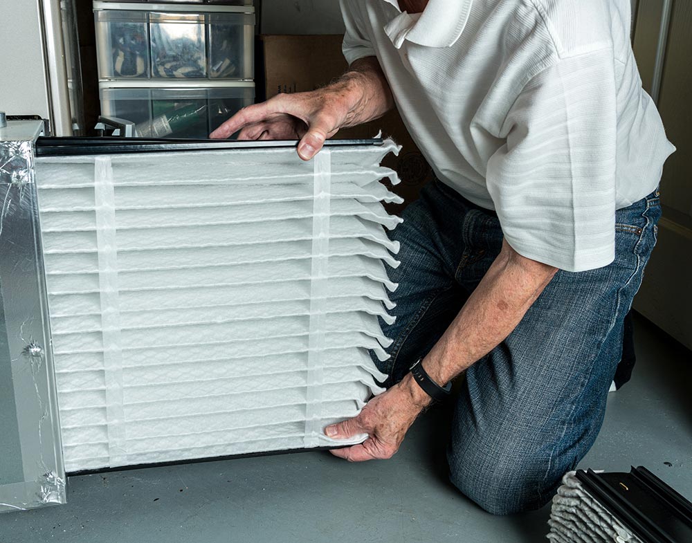 Man replacing an air filtration filter